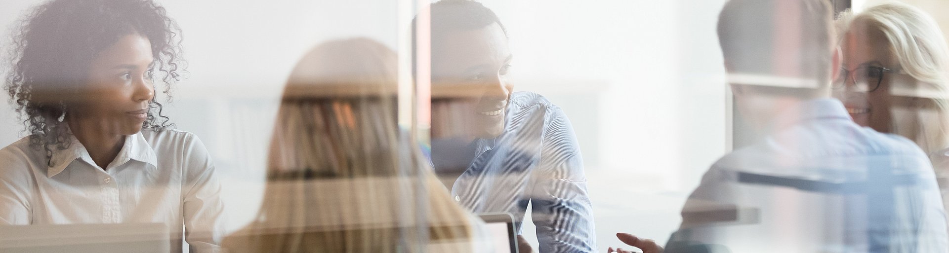 Multicultural employees talking at team meeting sit at conference table Multicultural employees talking at team meeting sit at conference table