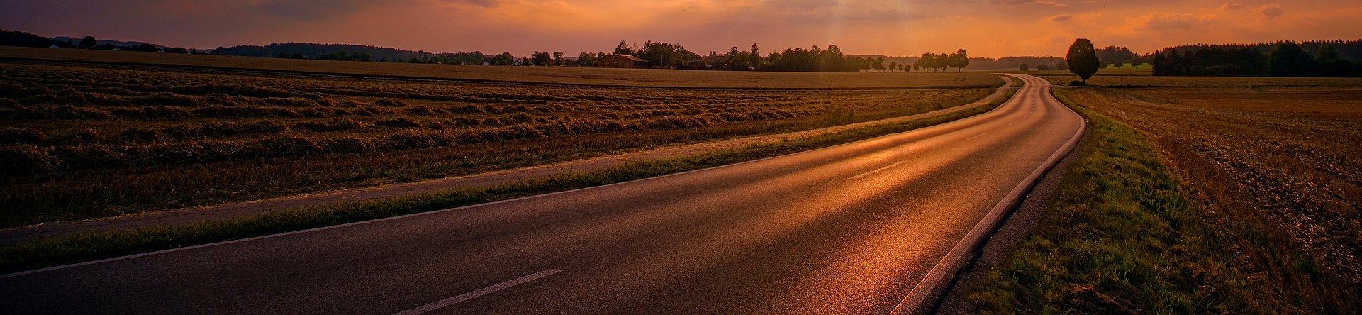 Sunset setting over a road in the countryside Sunset setting over a road in the countryside