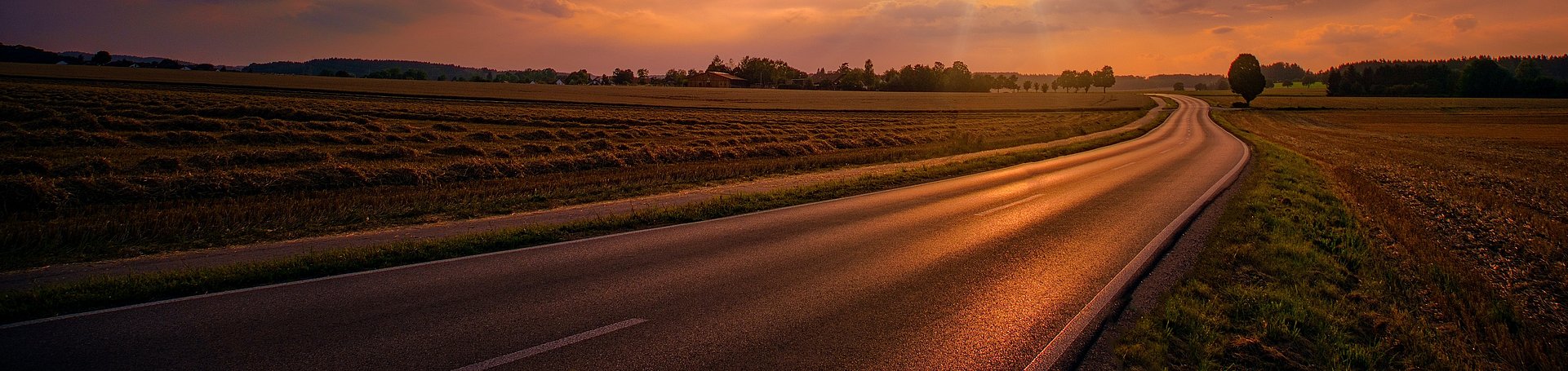 Sunset setting over a road in the countryside Sunset setting over a road in the countryside
